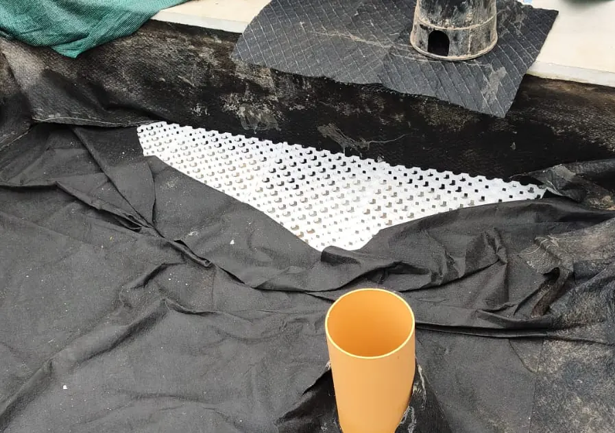 Celdas PlastiDren descubiertas bajo geotextil en jardinera